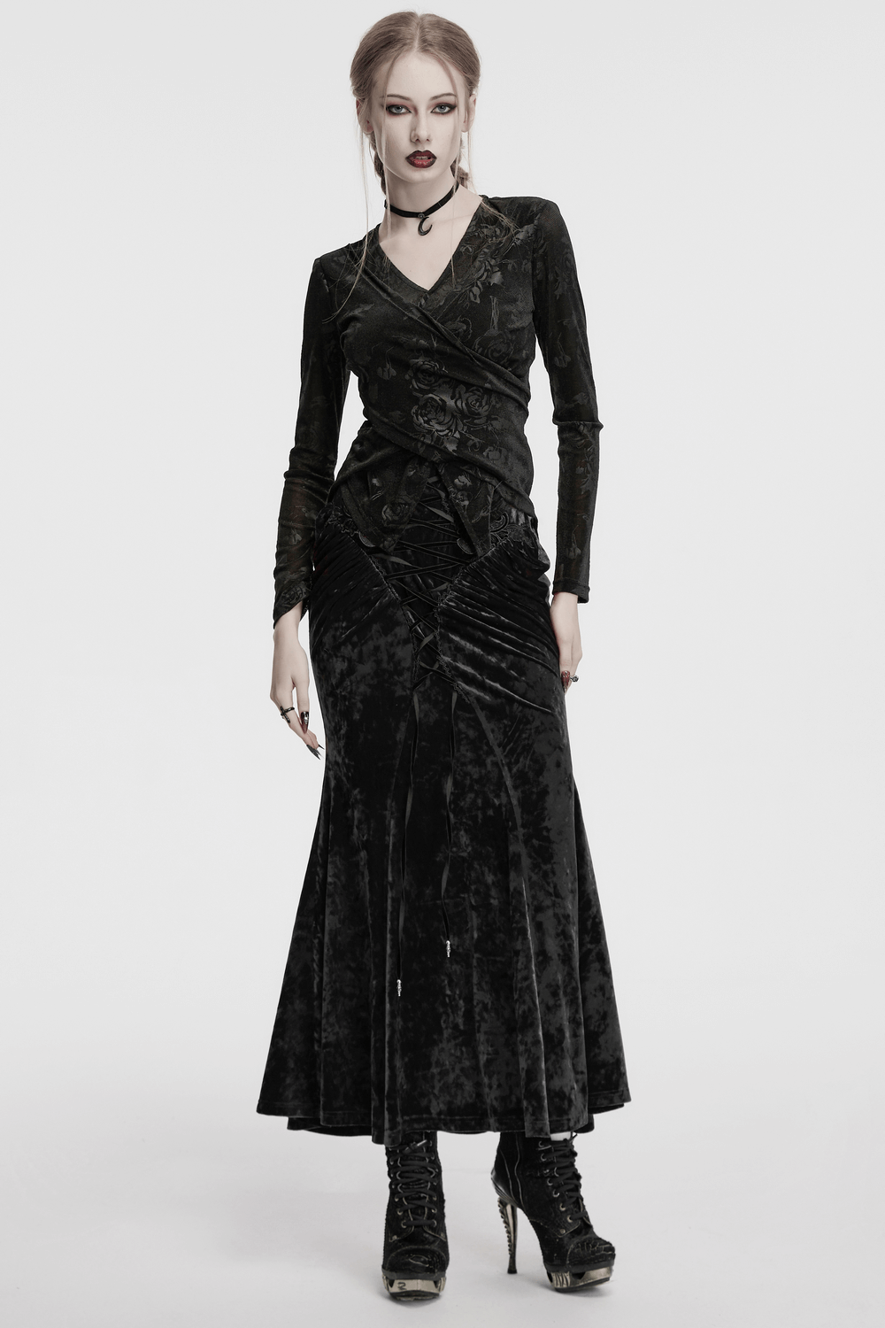 Elegant woman in vintage gothic velvet skirt with lace and pleats, exuding timeless dark fashion style.