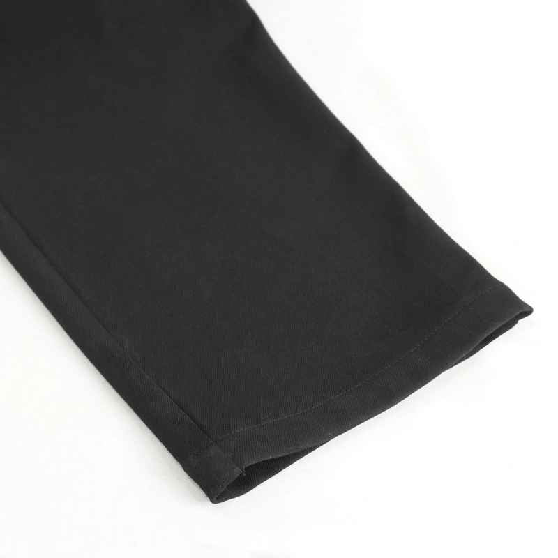 Close-up view of the hem of vintage high-waisted gothic pants showcasing sleek black fabric.