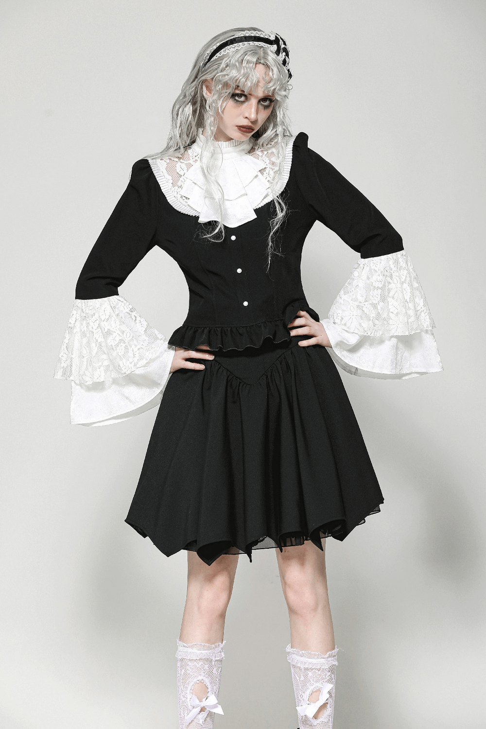 Vintage lace bell sleeved peplum blouse in black with white lace accents on bell sleeves and collar, paired with a flowing skirt.