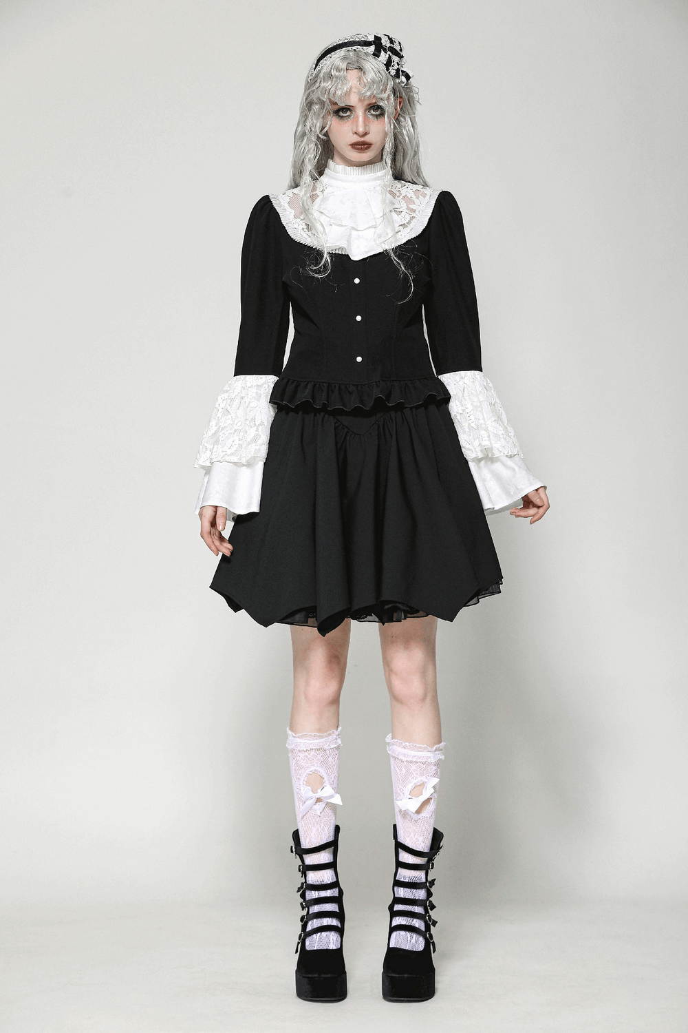 Model wearing a vintage black peplum blouse with white lace accents and a flared skirt, embodying retro elegance.