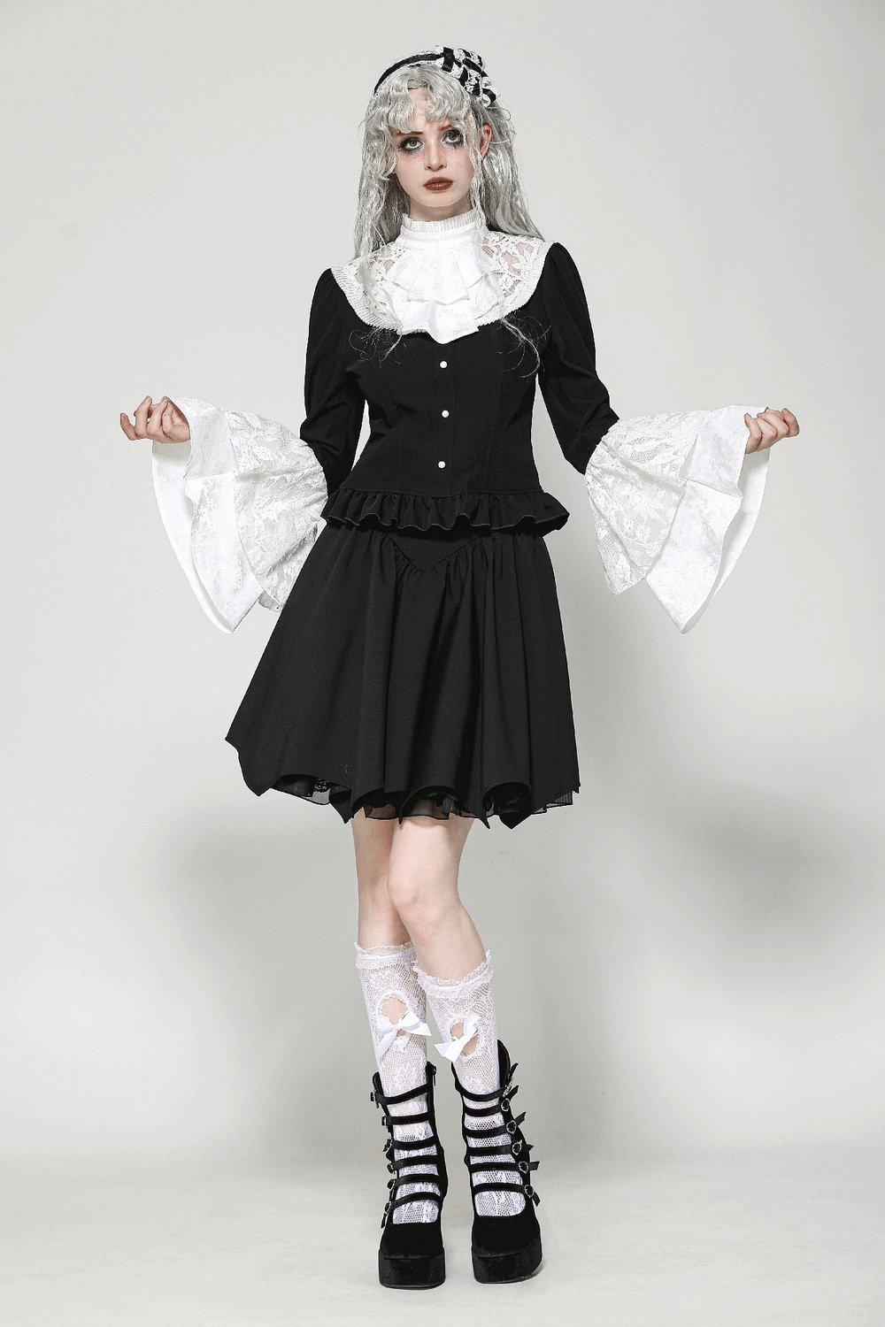 Gothic-inspired black dress with white lace bell sleeves and stylish platform shoes.