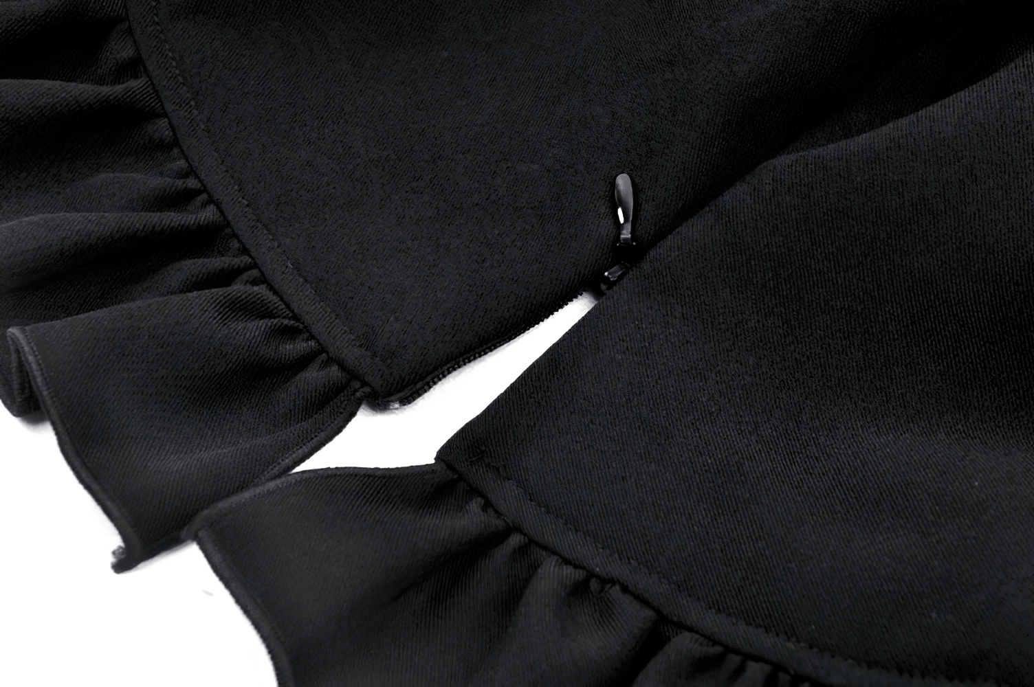 Close-up of black fabric with ruffled edges showcasing vintage lace peplum blouse detail.