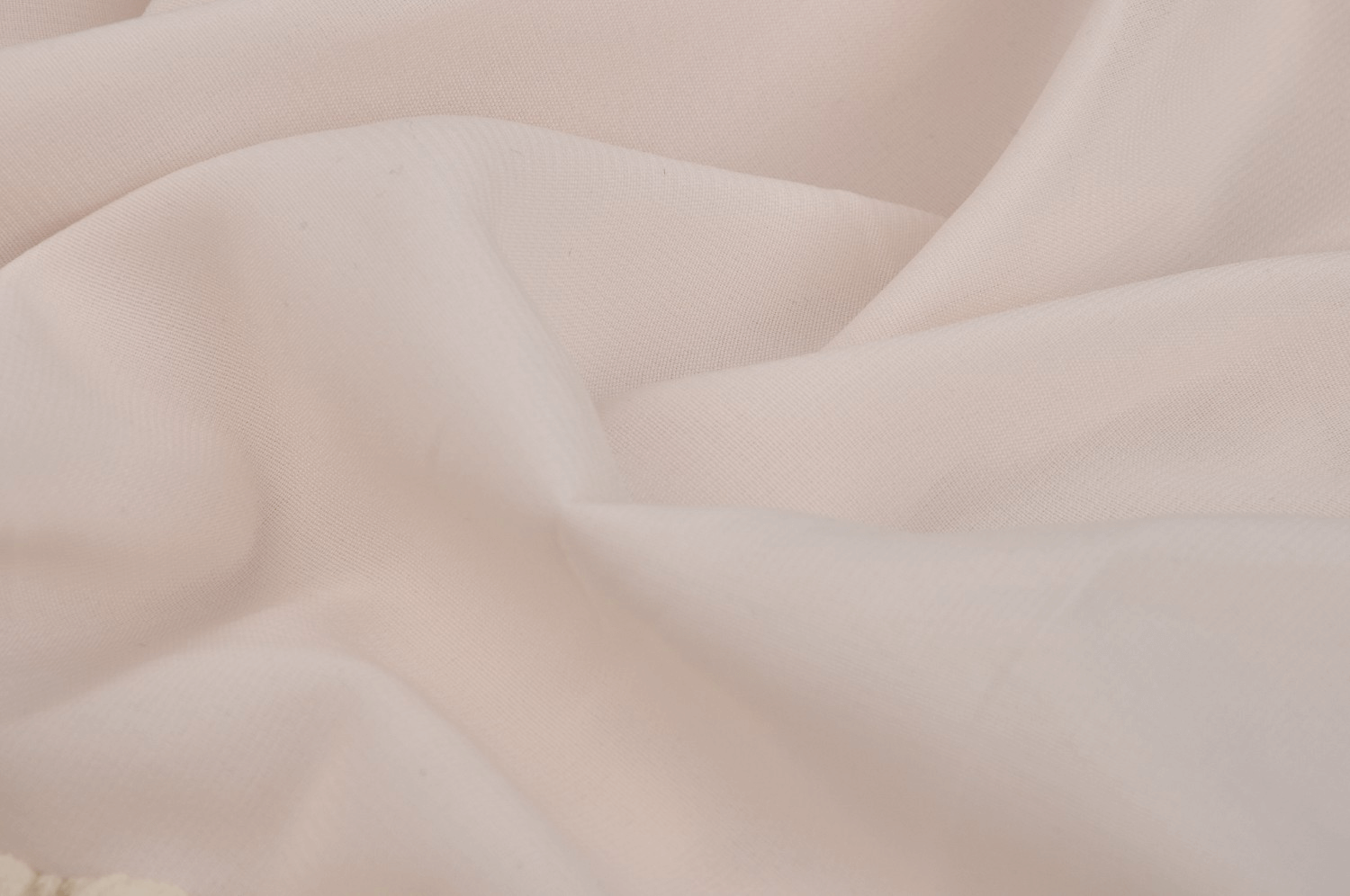 Close-up of soft, draped pale pink fabric showcasing a delicate texture, perfect for elegant dress designs.