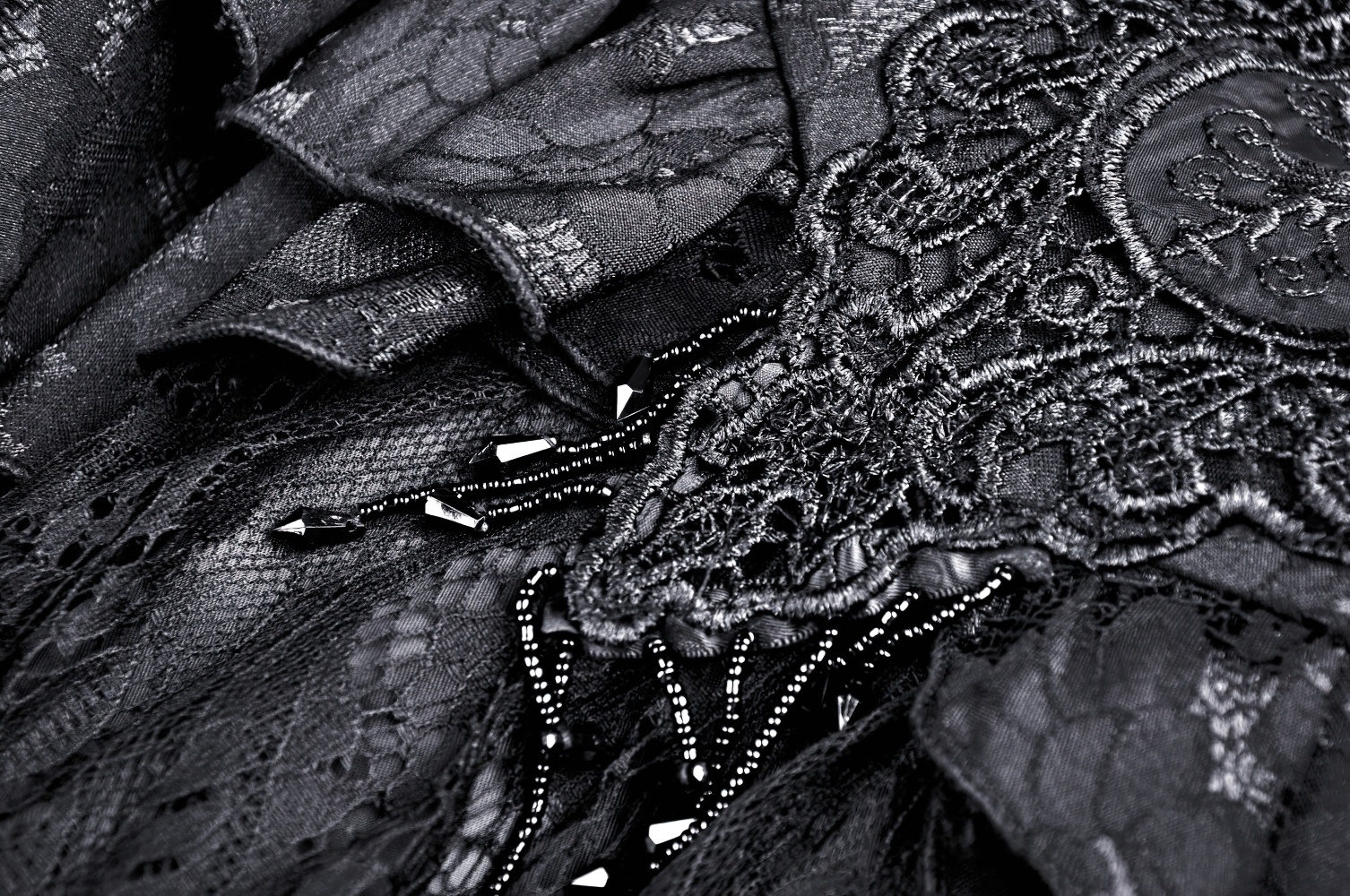 Close-up of black vintage lace layered skirt with intricate floral details and beaded embellishments.