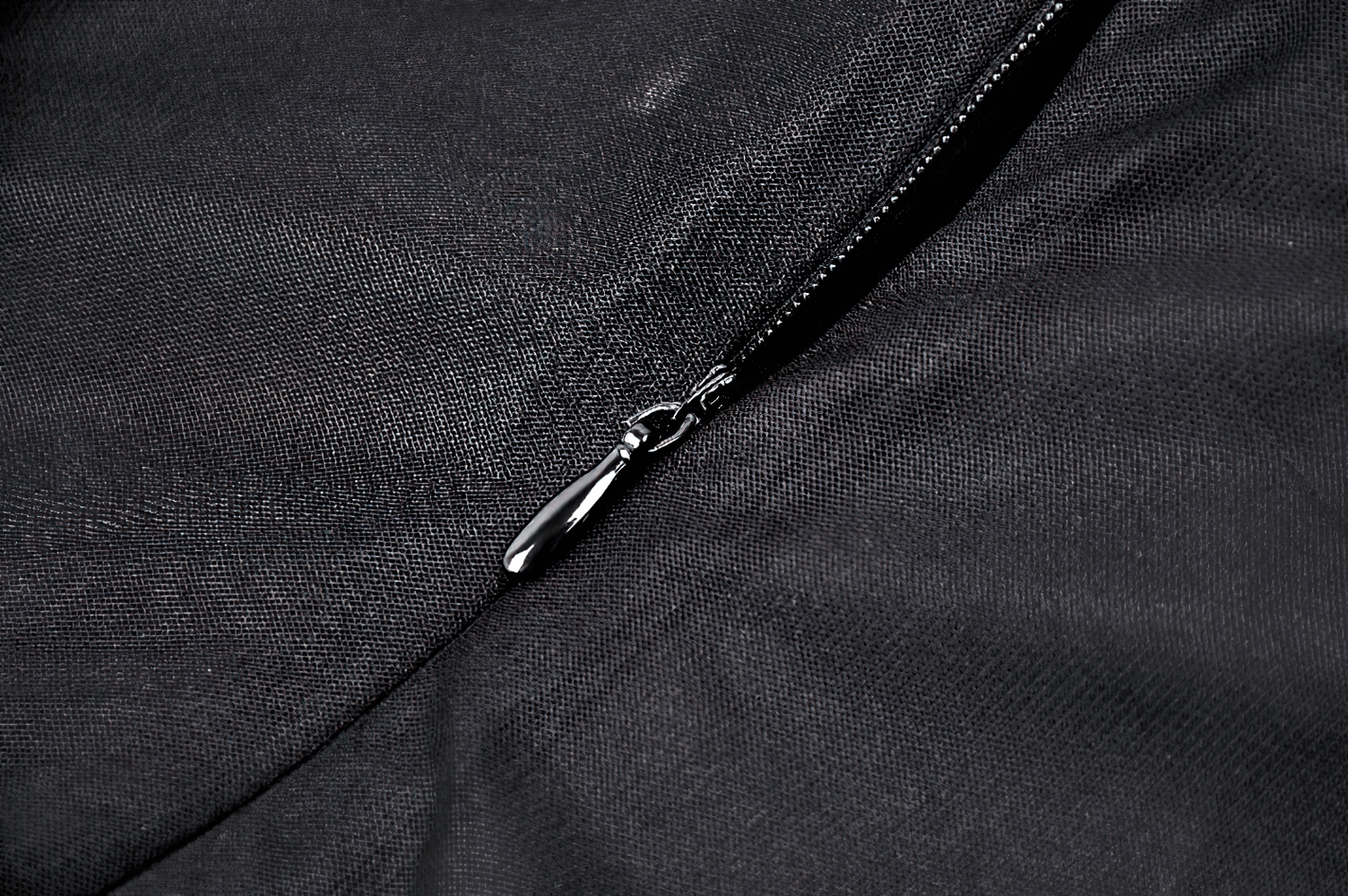 Close-up of zipper detail on a black vintage lace-up Gothic dress fabric.