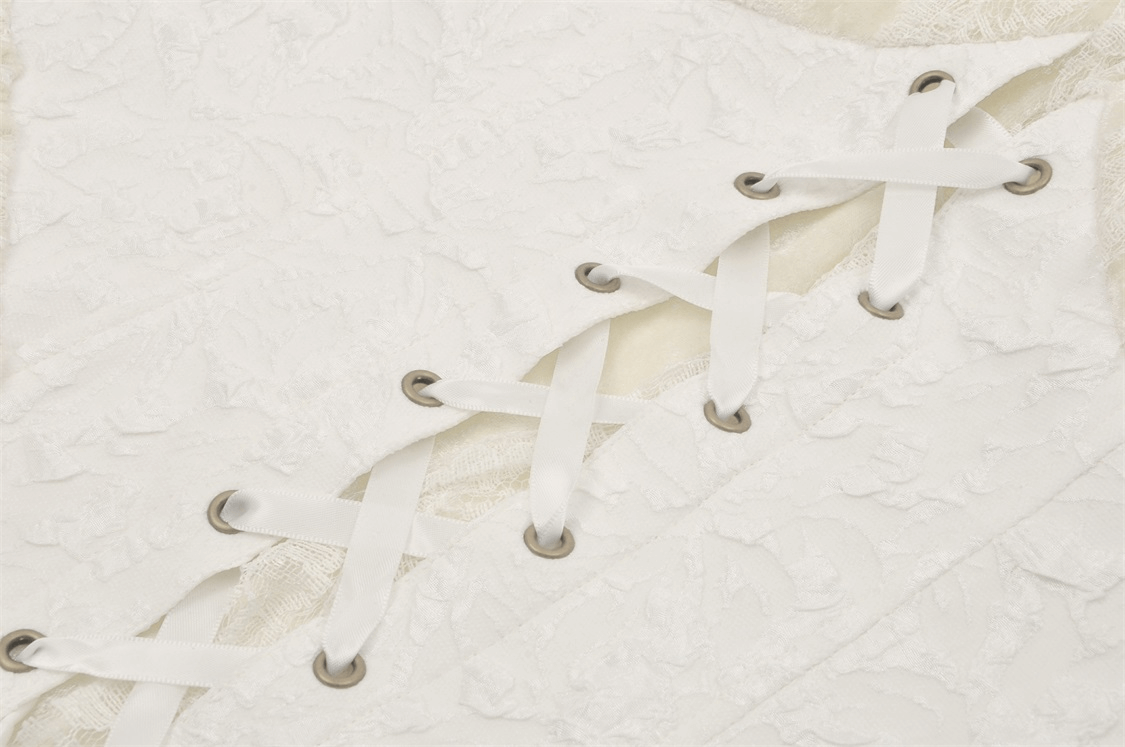 Close-up of intricate lace detailing and lace-up design on a vintage corset dress in elegant white.