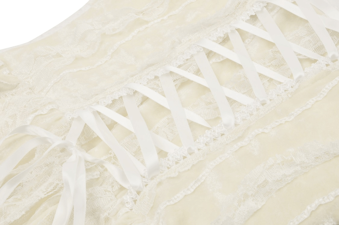 Close-up of beige vintage lace-up dress showcasing intricate lace and ruffled skirt details for a boho chic look.