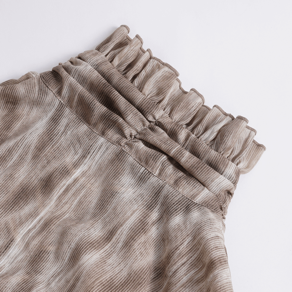 Close-up of ruffled waistband on a textured vintage skirt, showcasing its unique design and elegance.