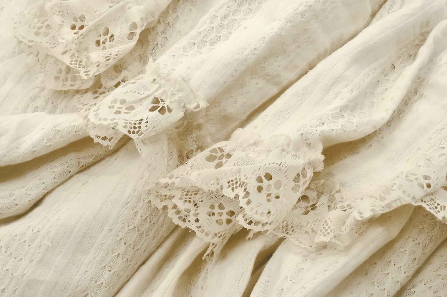 Close-up of vintage cream fabric with delicate lace trim and layered ruffles, perfect for a romantic boho aesthetic.
