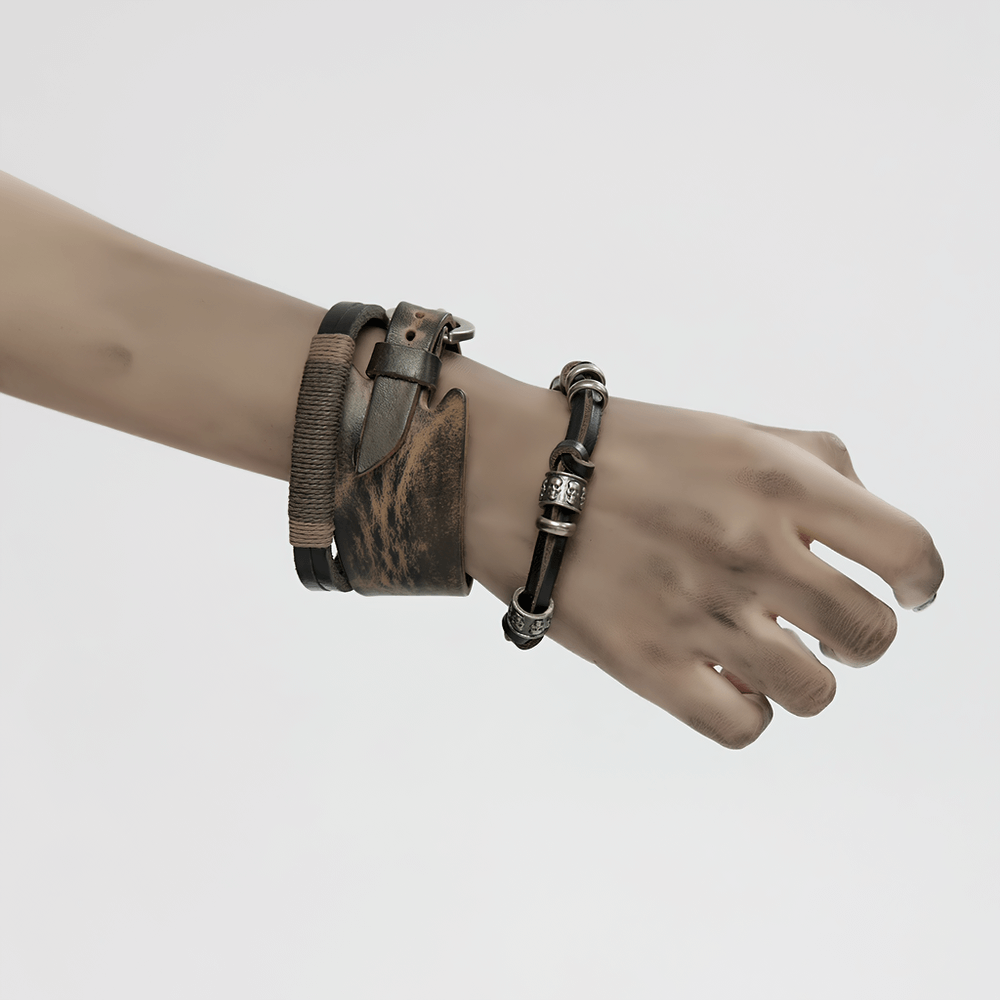 Hand wearing a vintage leather punk bracelet set with skull beads and metal accents, showcasing a rebellious style.