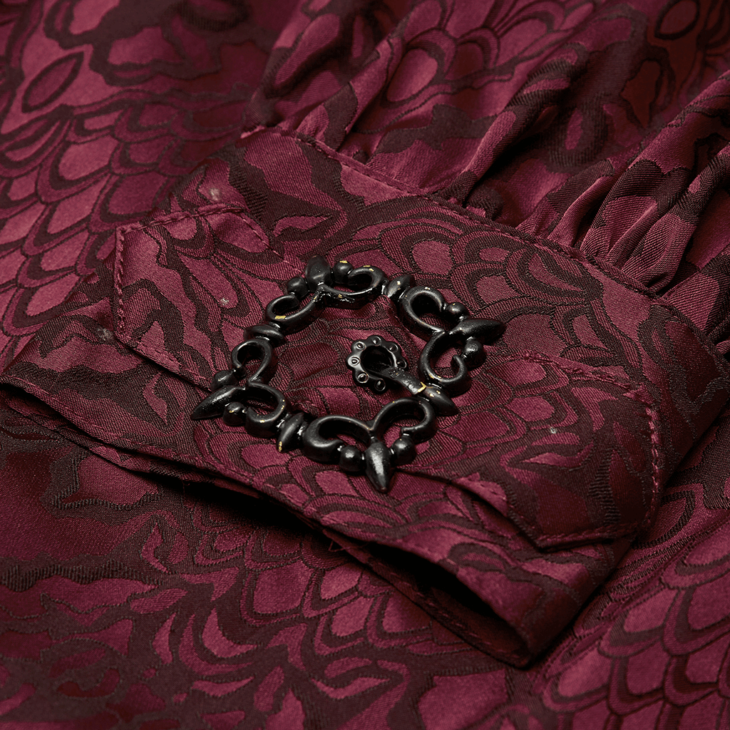 Close-up of a vintage gothic shirt cuff showcasing intricate dark jacquard fabric and a stylish lace detail.