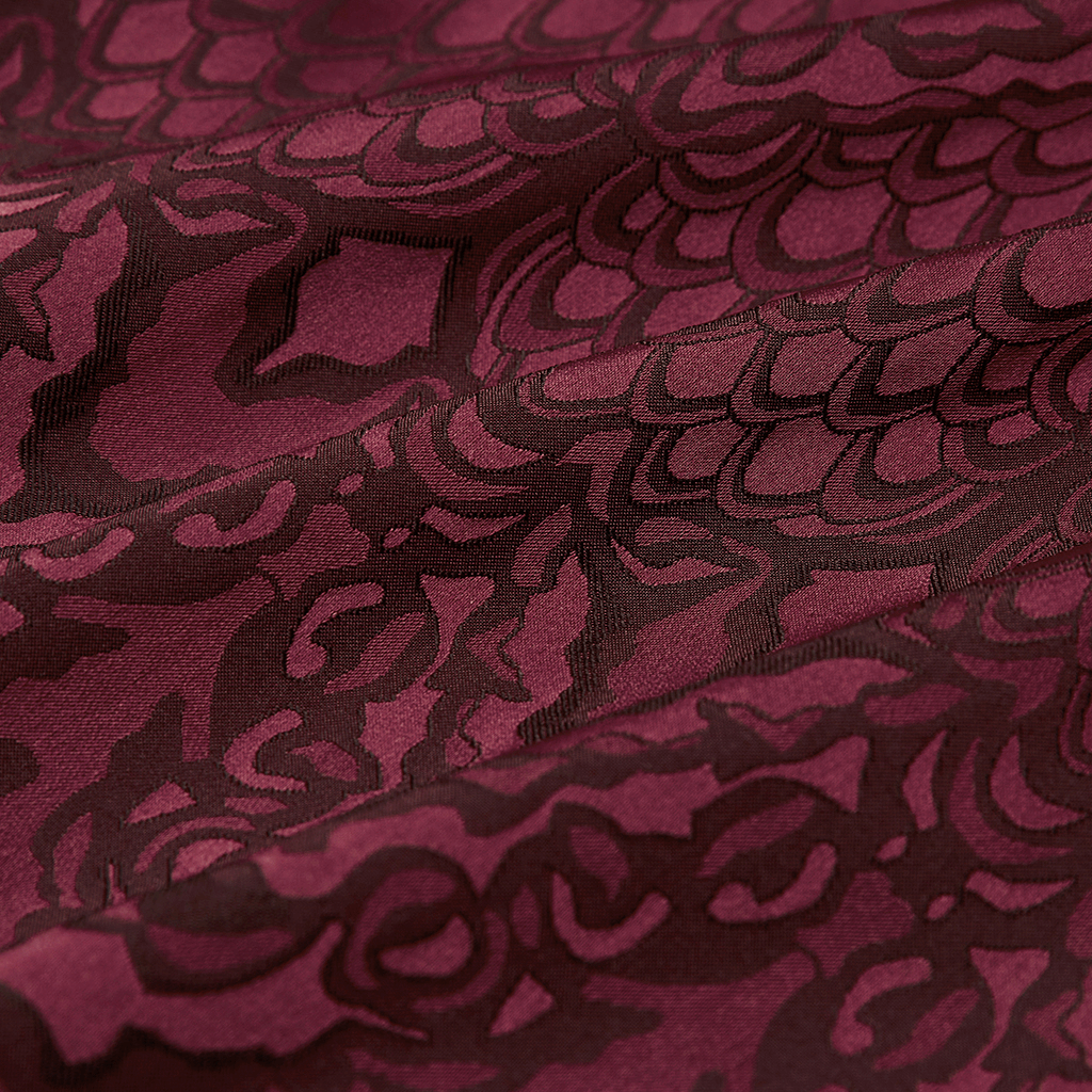 Close-up of deep plum Gothic jacquard fabric featuring intricate black lace patterns.