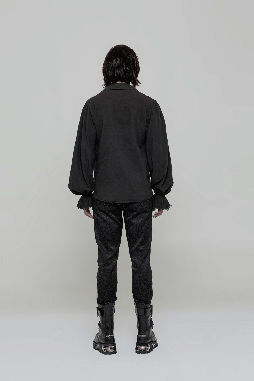 Back view of a man wearing a vintage Gothic long sleeve shirt and stylish black pants, showcasing steampunk fashion.