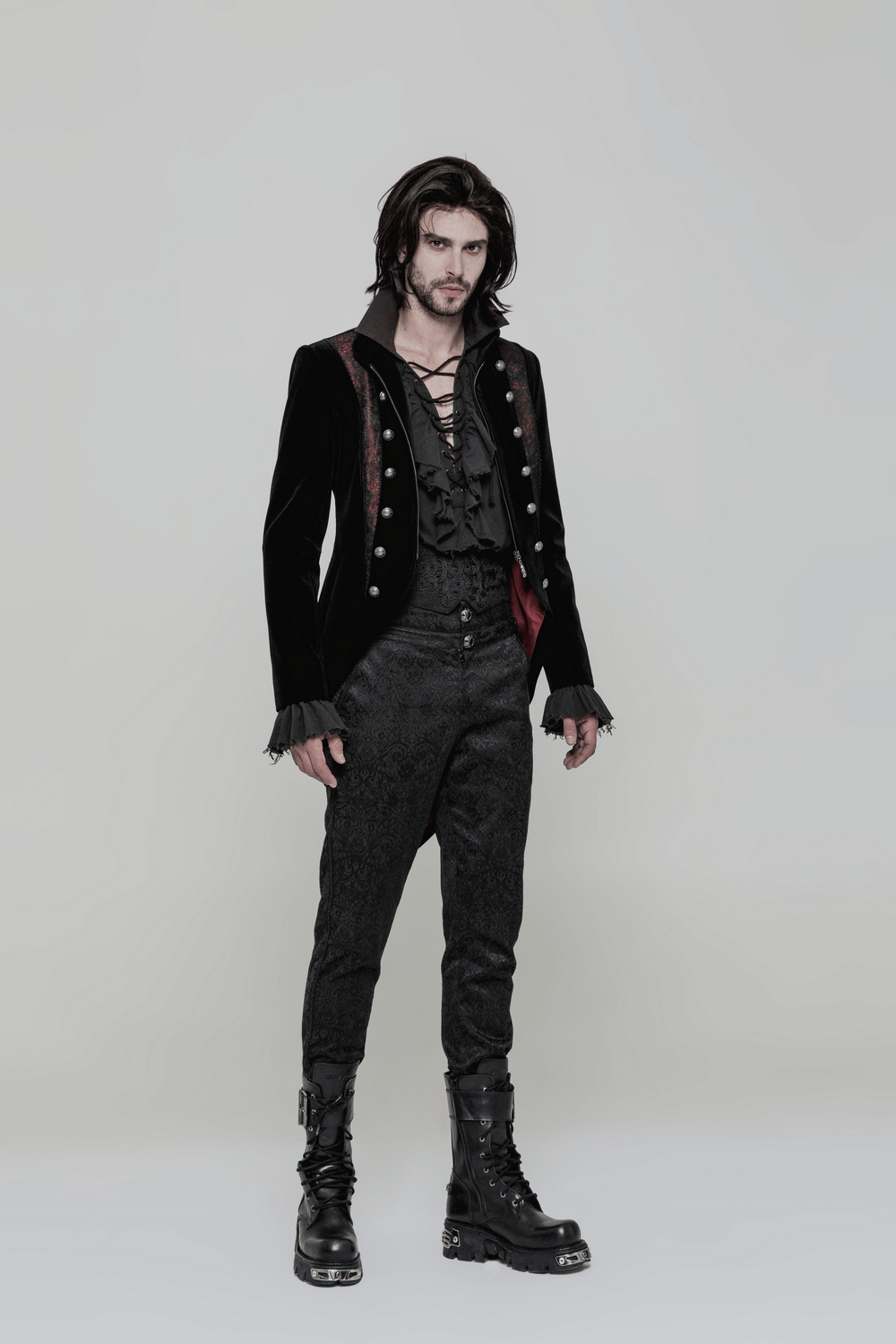 Stylish man in vintage Gothic long sleeves shirt with ruffles and steampunk vibes, wearing black pants and boots.