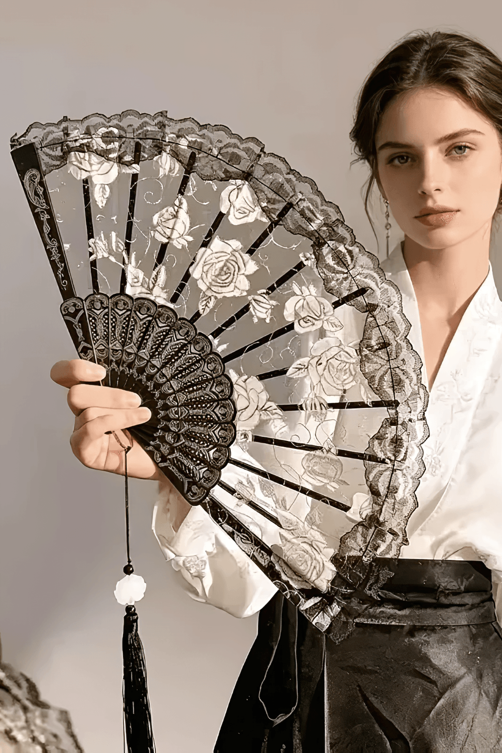 Vintage Rose Lace Folding Fan with Tassel Pendant held by a model, showcasing gothic elegance and intricate lace design.