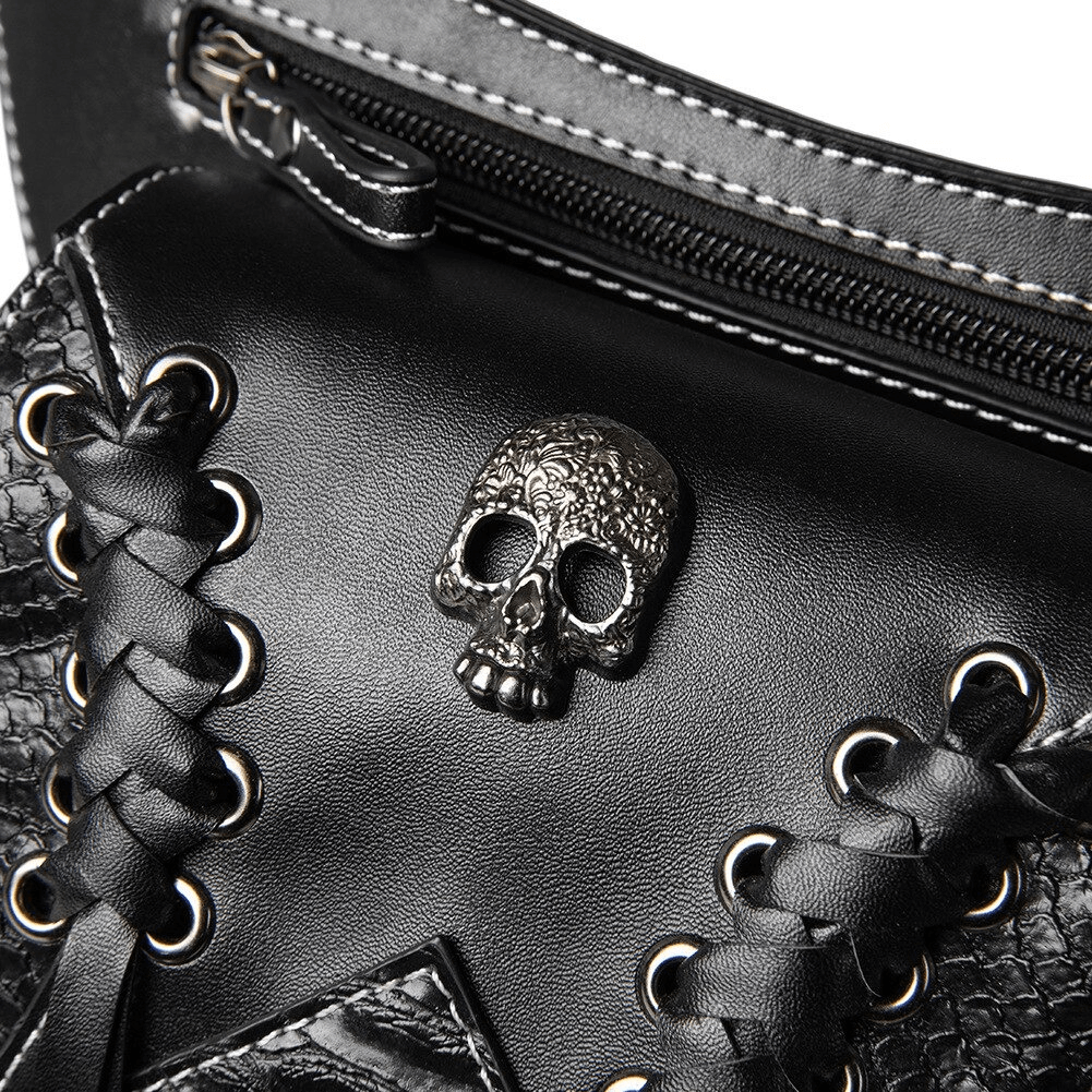 Close-up of vintage skull detail on black multifunction leather bag, showcasing gothic punk fashion style.
