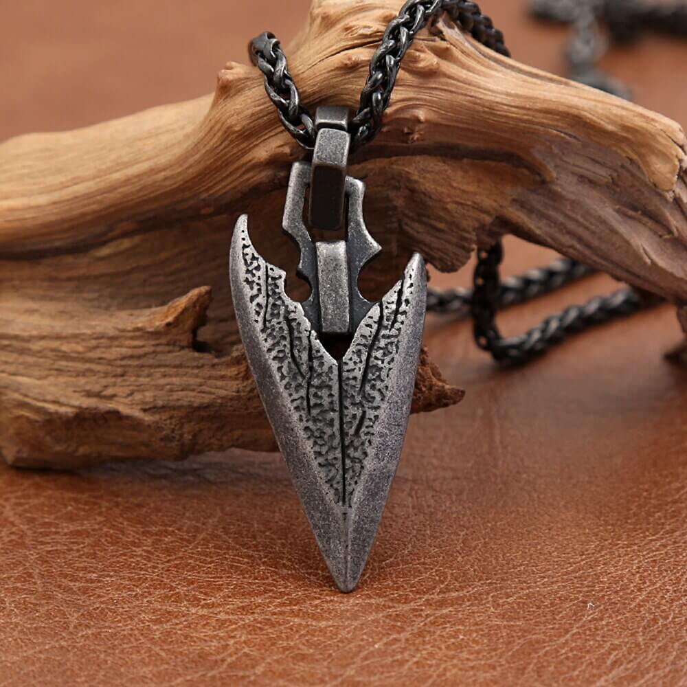 Unisex vintage stainless steel arrowhead pendant necklace on rustic wood, a bold fashion amulet accessory.
