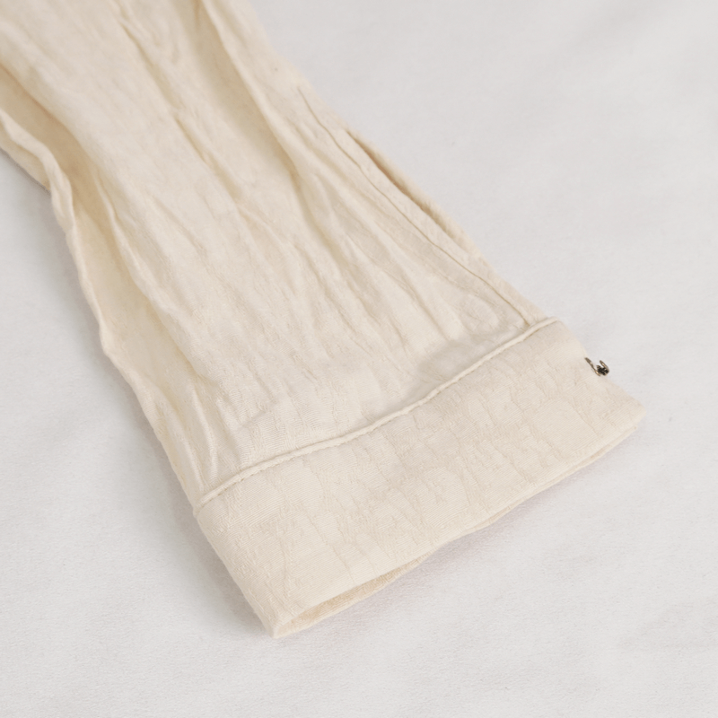 Close-up of the cuff of a vintage stand collar cotton shirt showing soft fabric and button details.