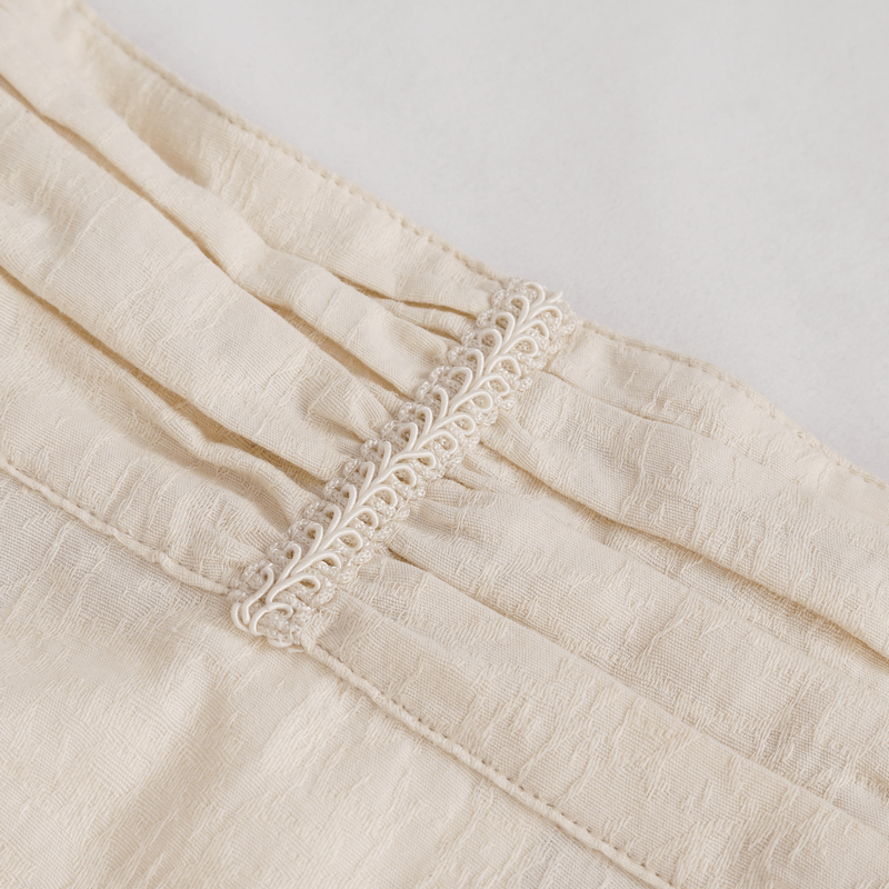 Close-up of vintage stand collar cotton shirt showing elegant button detail and soft fabric texture.