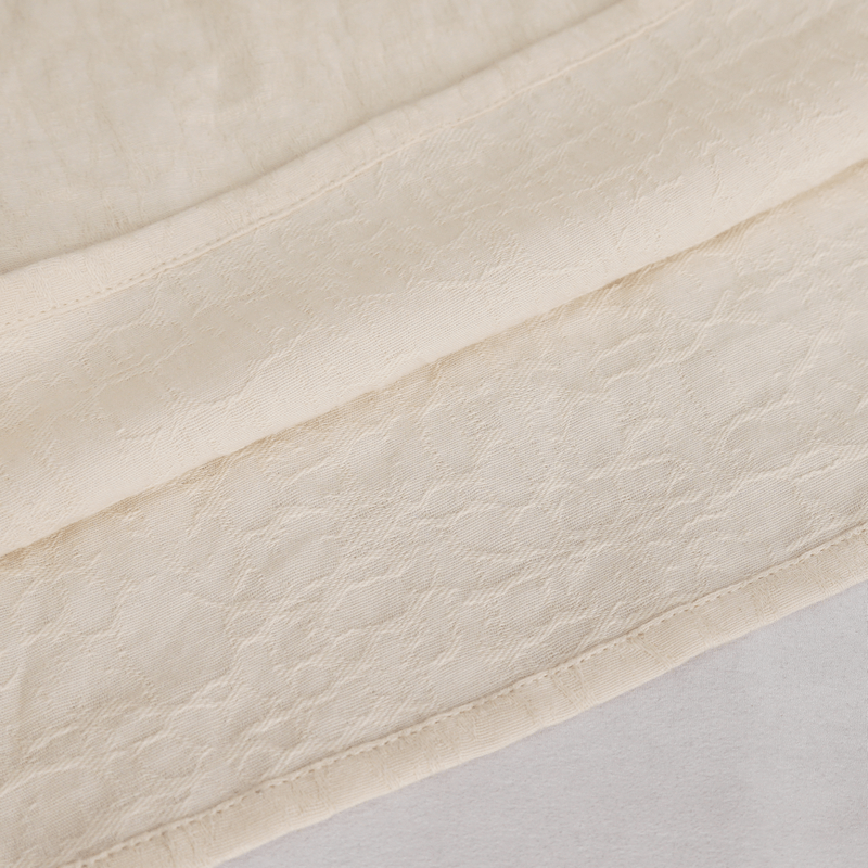 Close-up of soft vintage cotton fabric with a delicate texture, showcasing the quality of a loose-fit shirt.