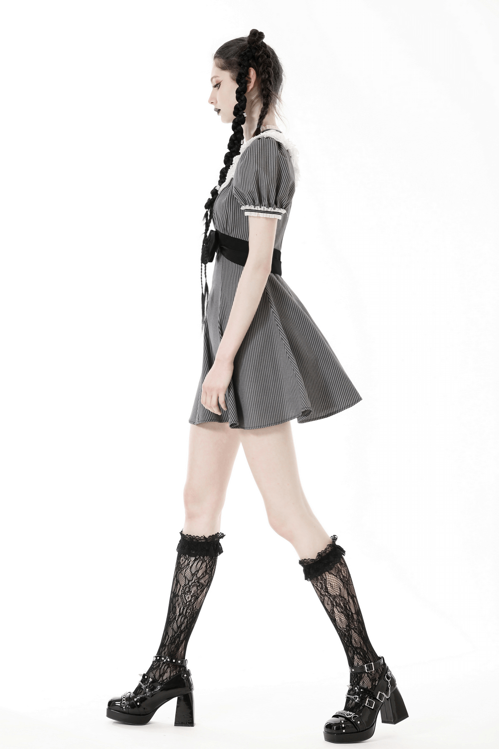 Model in a vintage striped dress with lace and bow, styled with knee-high socks and platform shoes.