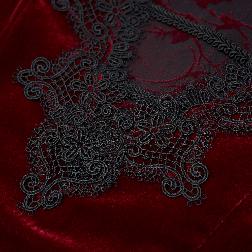 Close-up of intricate black lace detail on vintage red velvet fabric, highlighting elegant gothic design.