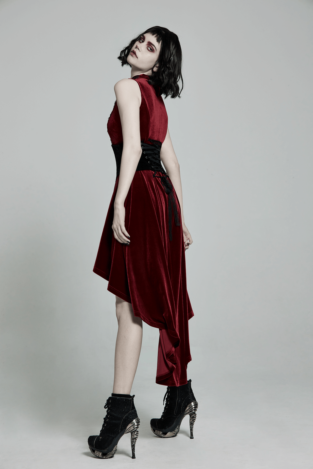 Gothic model in vintage velvet cincher dress with lace-up back, showcasing elegance and style.