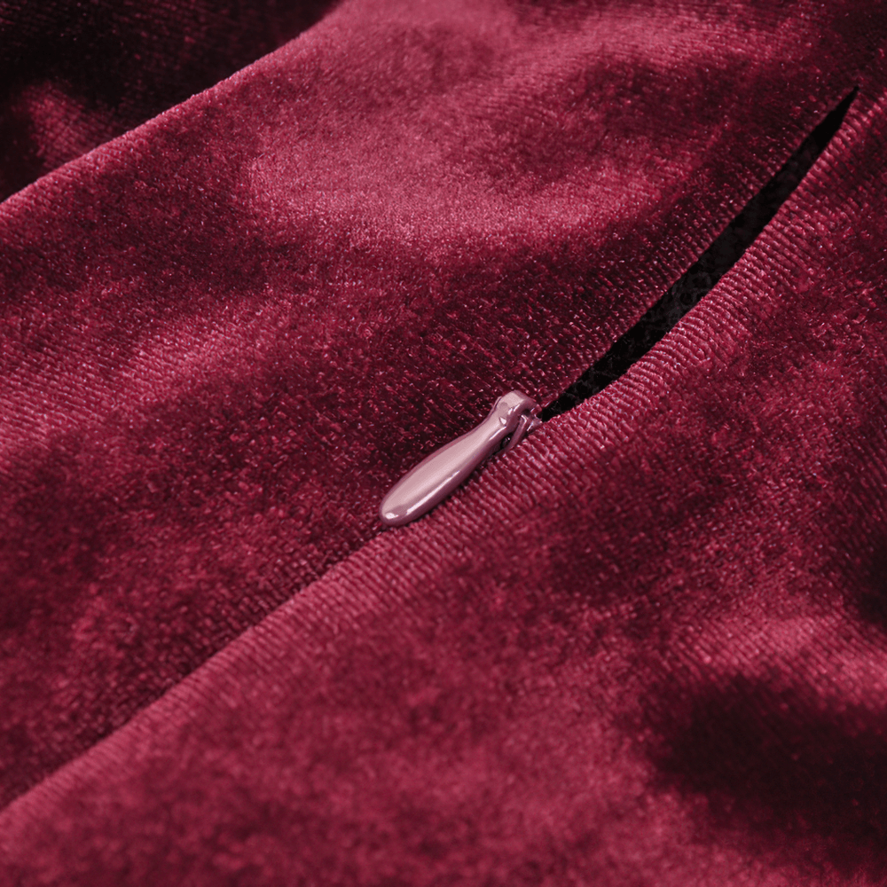 Close-up of burgundy velvet fabric with a black zipper detail on a vintage-inspired gothic mini dress.