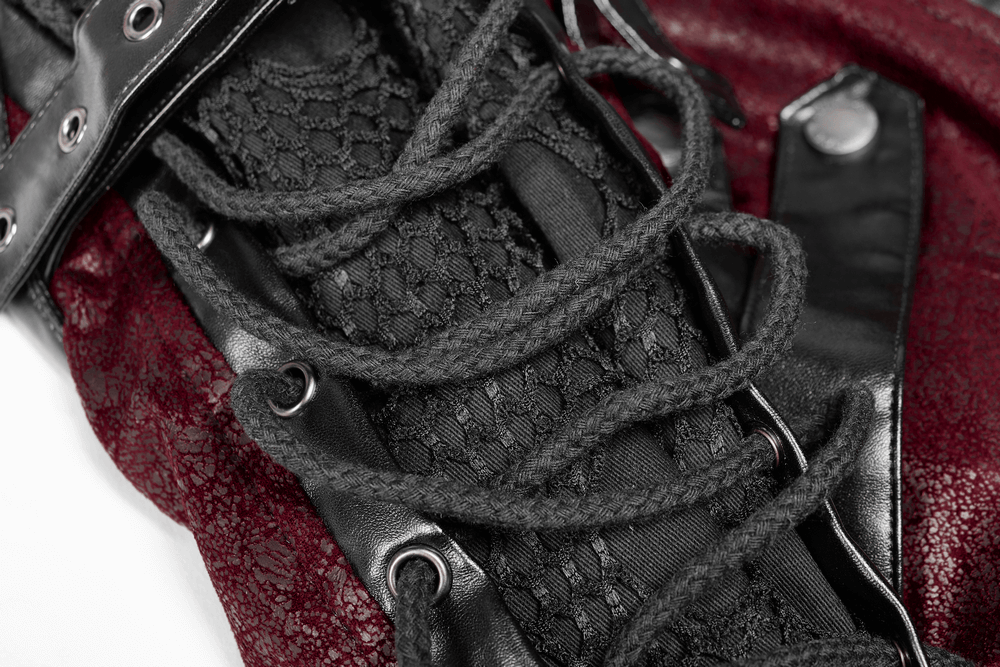 Close-up of vintage women's leather punk jacket with straps and intricate lace detailing in red and black.