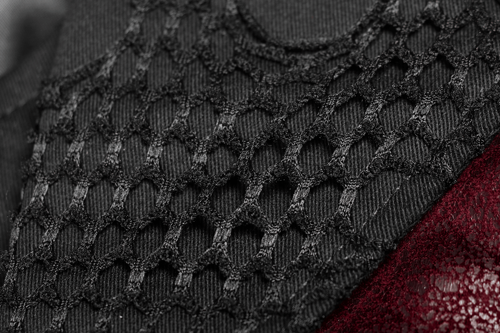 Close-up of textured black mesh fabric and red leather, showcasing a punk-inspired design.