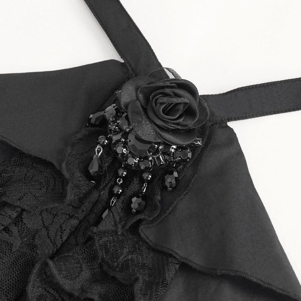 Close-up of gothic black blouse featuring lace, ruffles, and a decorative rose with beads.