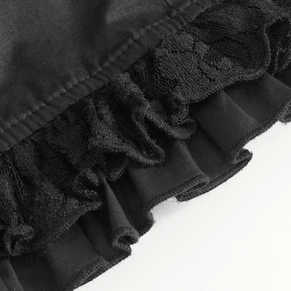 Close-up of black lace and ruffles on a vintage gothic blouse, showcasing elegant detailing.