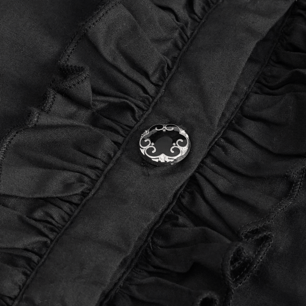 Close-up of a black vintage blouse featuring lace inserts and ruffles with a decorative button detail.