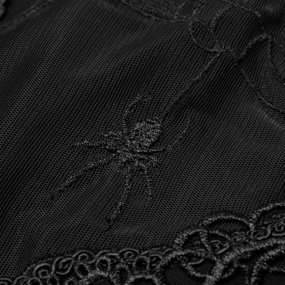 Close-up of black fabric featuring intricate spiderweb and spider embroidery design.