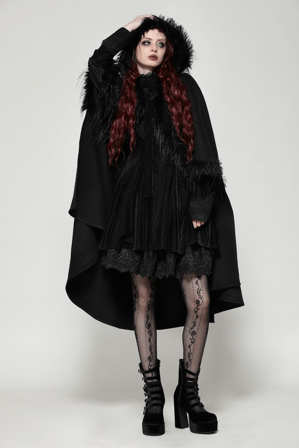 Elegant model in a warm black hooded cape with faux fur trim, showcasing gothic style and dramatic flair.