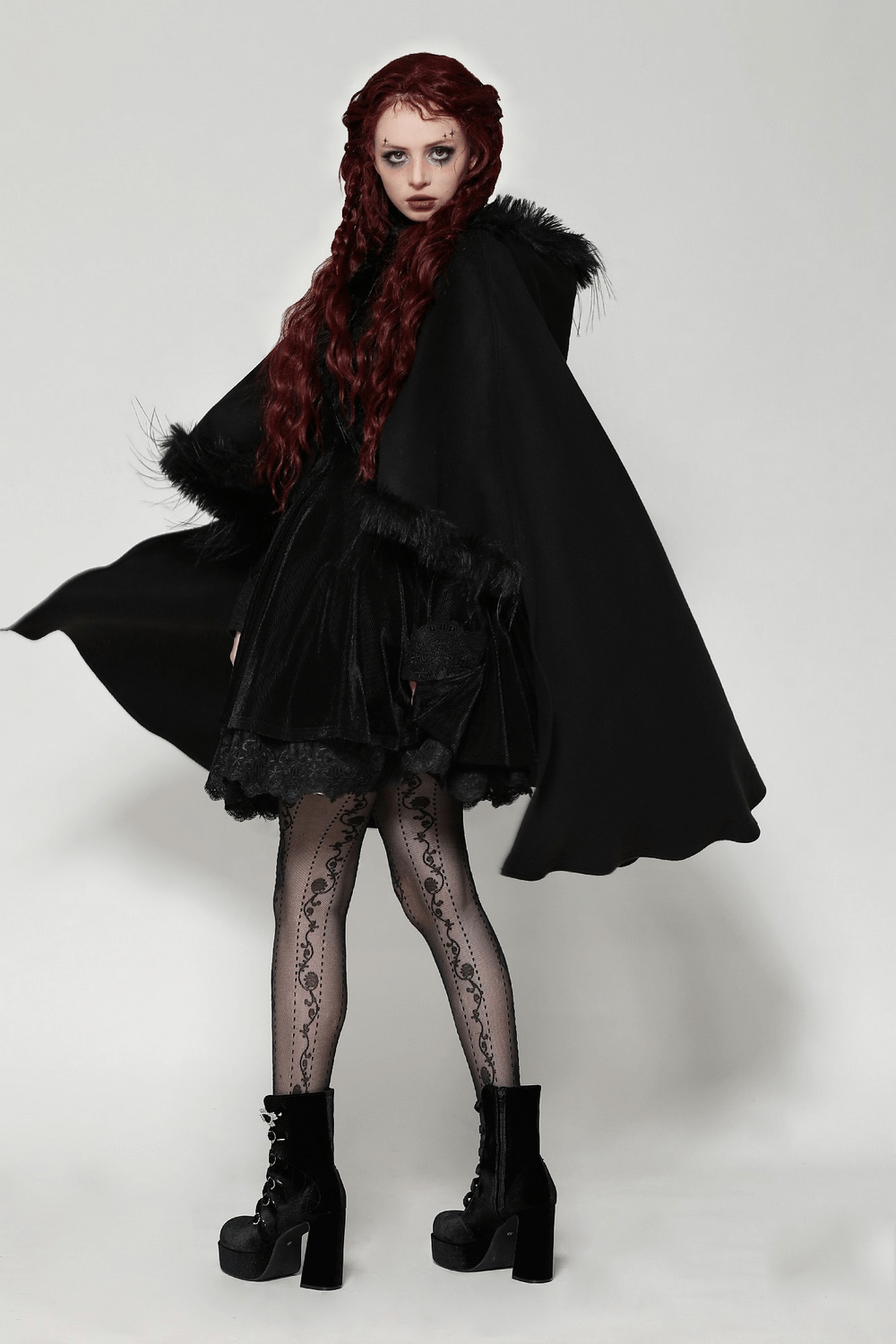 Elegant gothic hooded cape with faux fur trim, paired with a black dress and lace stockings, creating a dramatic look.