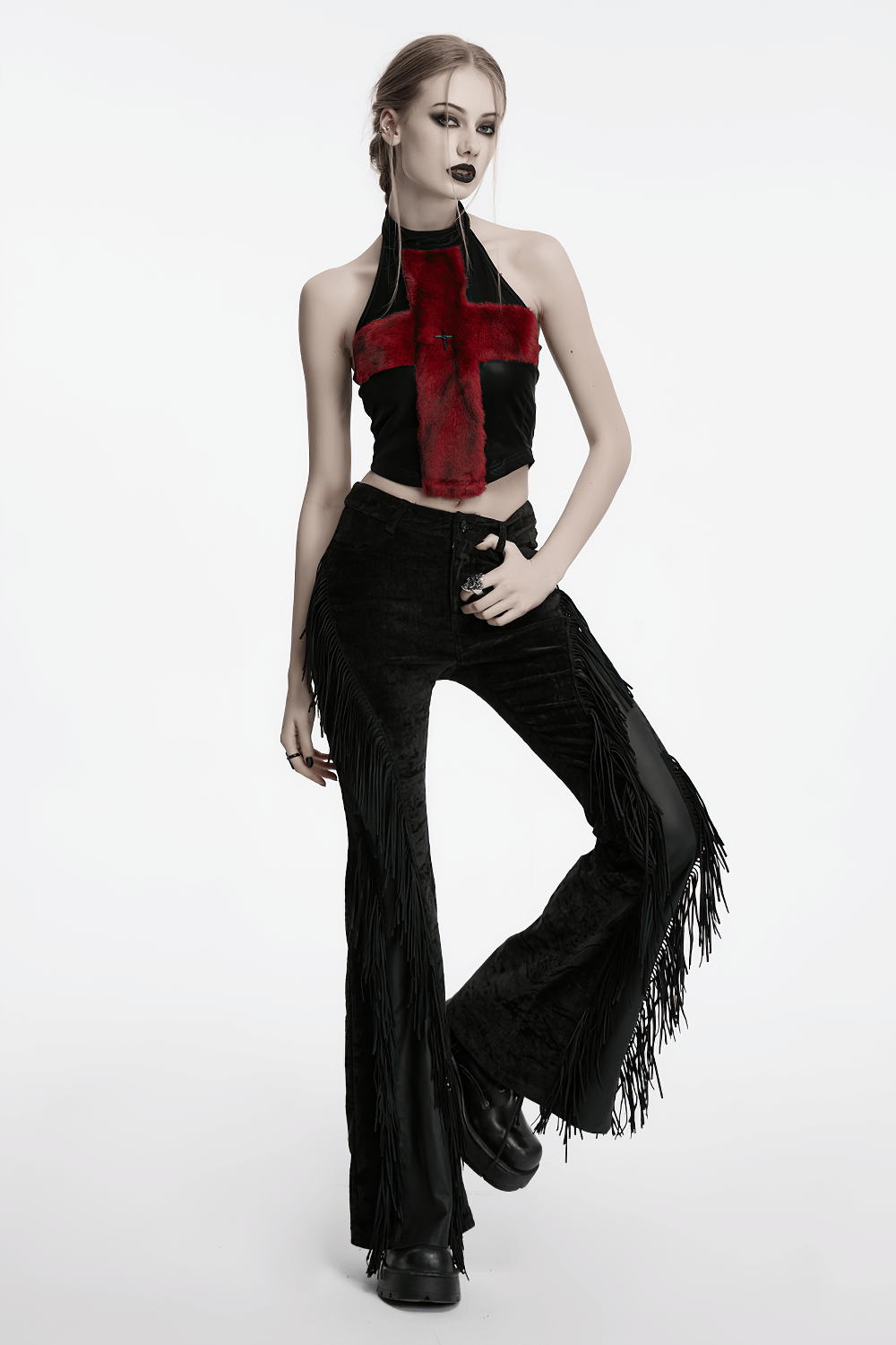 Gothic model in black tassel flare pants with velvet detailing and red cross crop top, showcasing bold alternative fashion.