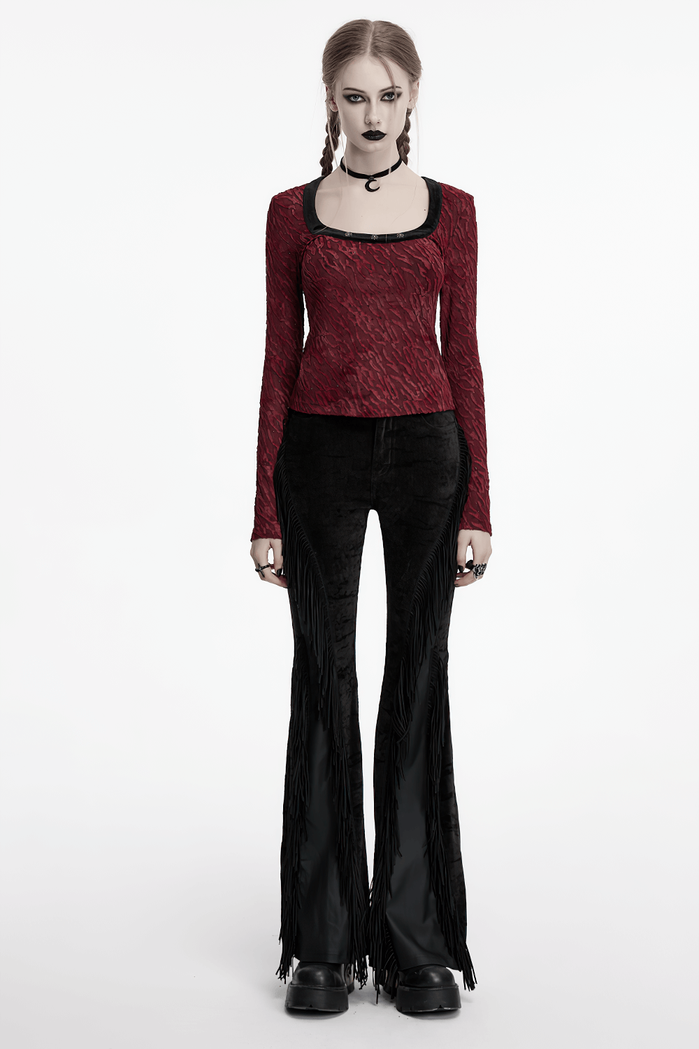 Gothic model in black tassel flare pants, showcasing unique velvet detailing and a bold, alternative fashion statement.