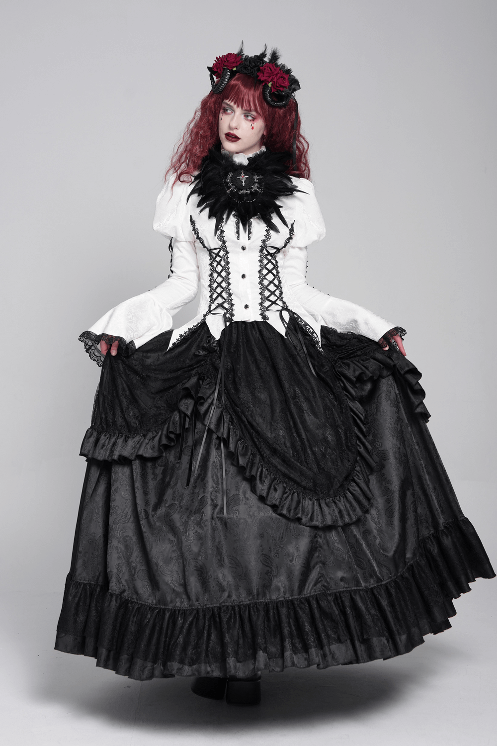 Victorian gothic model in white blouse with lace, corset ties, and a dramatic black skirt, showcasing a steampunk look.