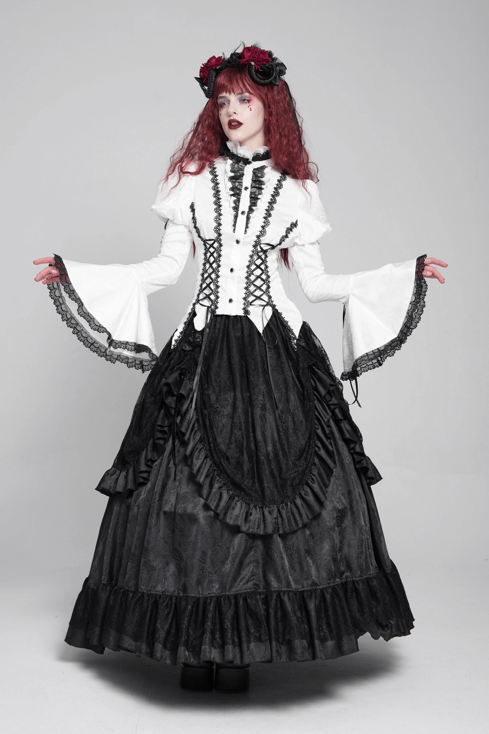 Stunning white gothic lace Victorian blouse with corset ties, flared sleeves, and elegant black skirt for a dramatic look.
