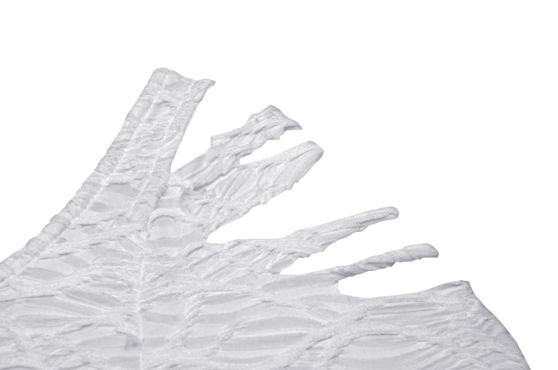 Close-up of white gothic dress detailing with dramatic trumpet sleeve and cutout design.