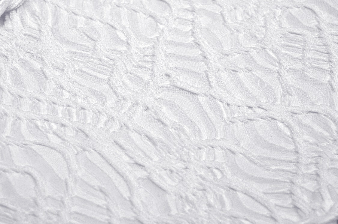 Close-up of textured white fabric with intricate detailing, perfect for a gothic maxi dress.