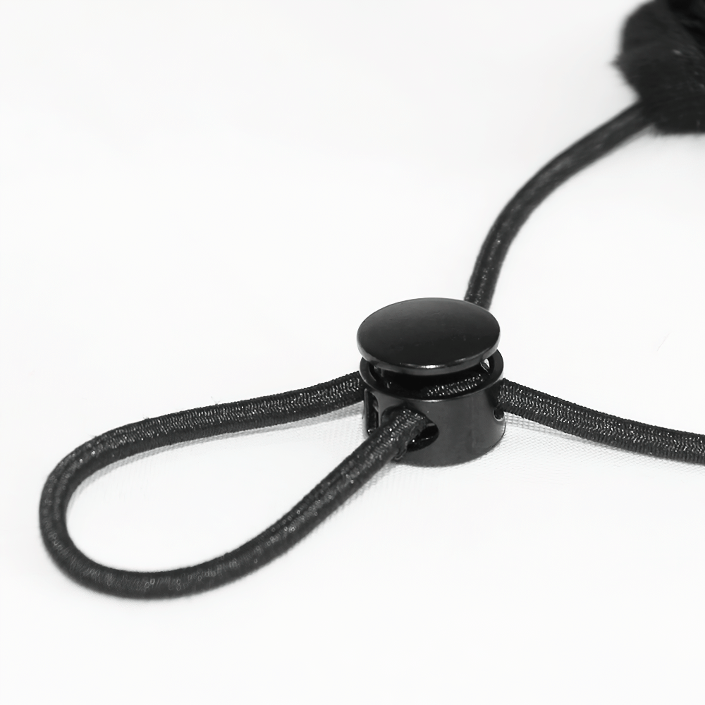Close-up of a black lace-up toggle used in stylish women's white lace masks for a perfect fit.