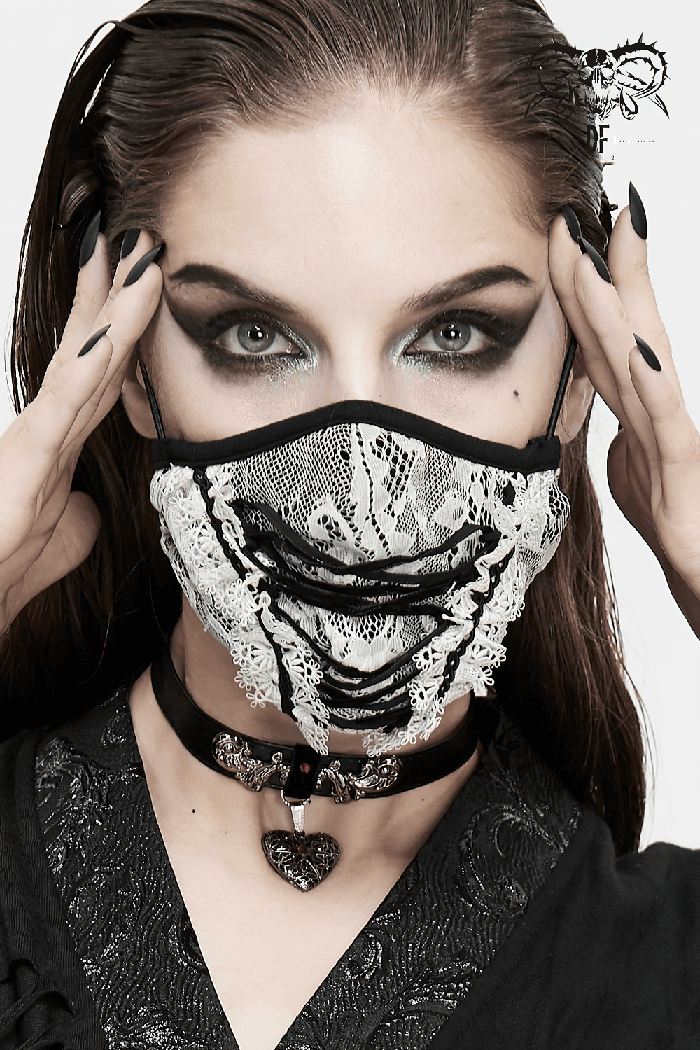 Gothic white lace fashion mask with black lace-up, styled elegantly on a woman with striking makeup.