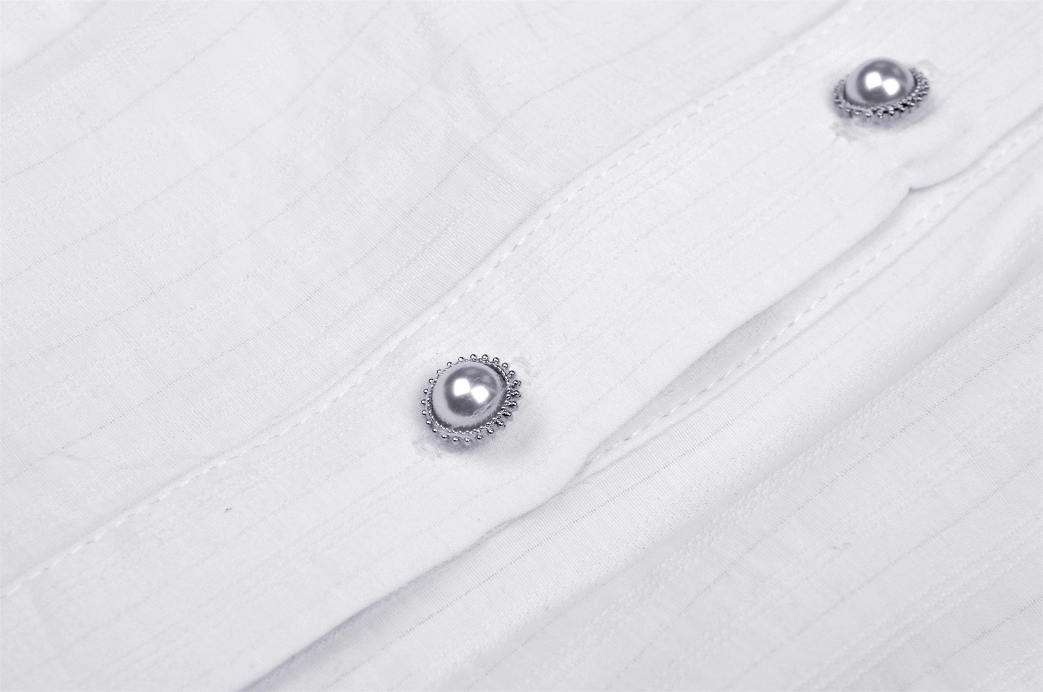 Close-up of elegant white blouse buttons with lace detailing, perfect for a Victorian-inspired outfit.