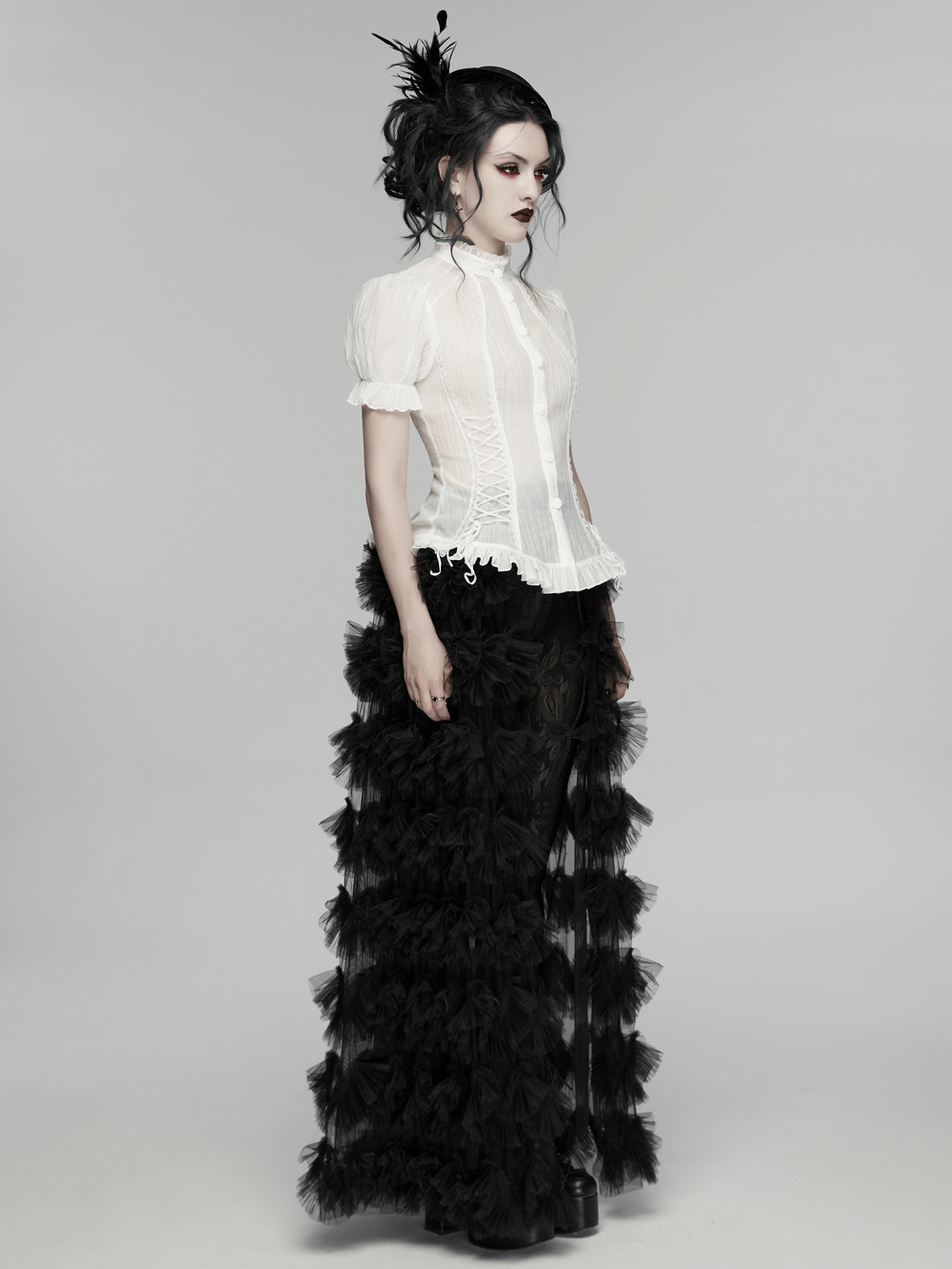 White Retro Lace-up Corset Blouse with Puff Sleeves modeled with dramatic black ruffled pants for a gothic vintage look.