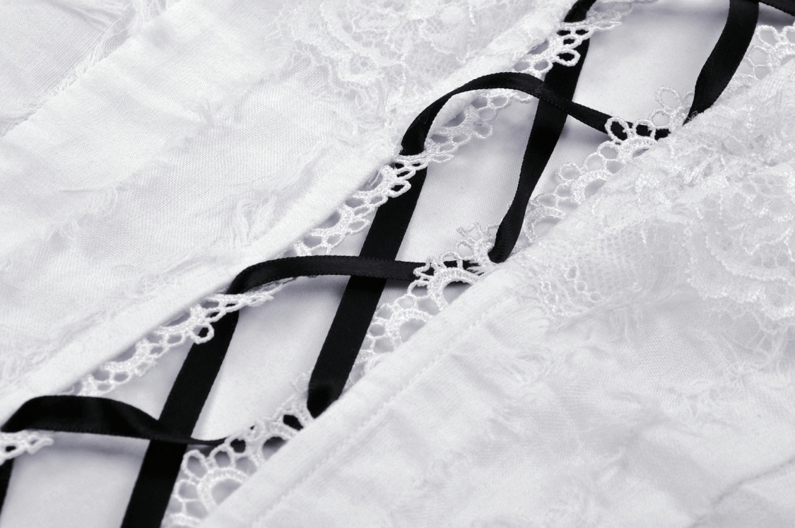 Close-up of white lace-up crop top with black ribbons and intricate lace detailing, perfect for a punk-inspired outfit.