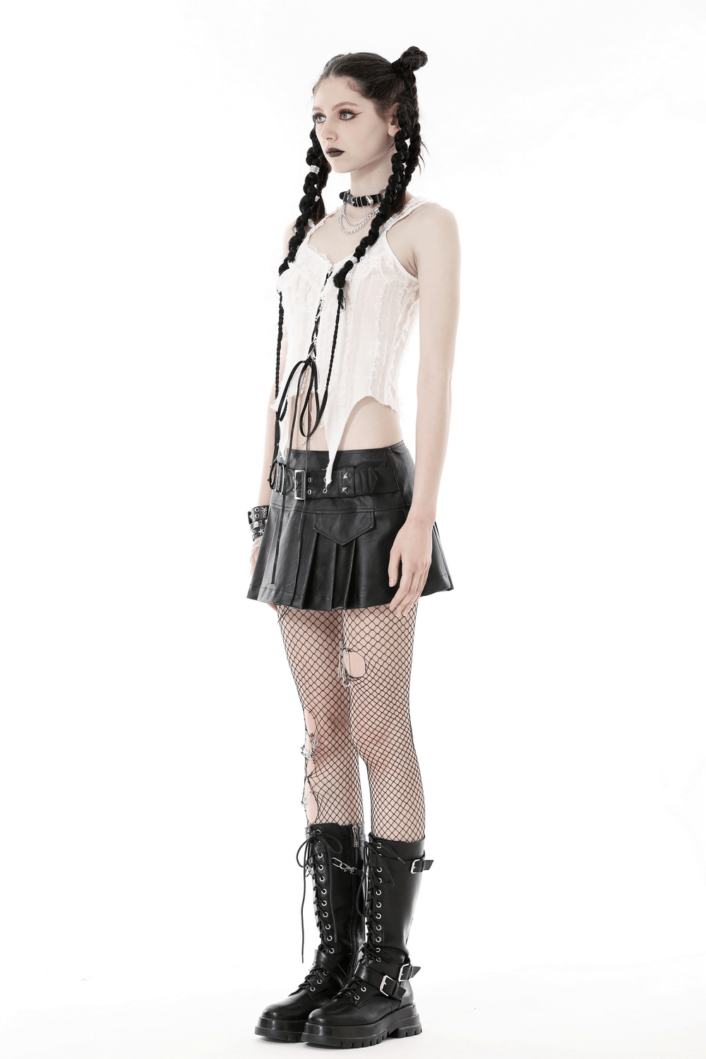 Model showcases white sleeveless crop top with black lace-up, paired with a black skirt and combat boots, exuding punk rock style.