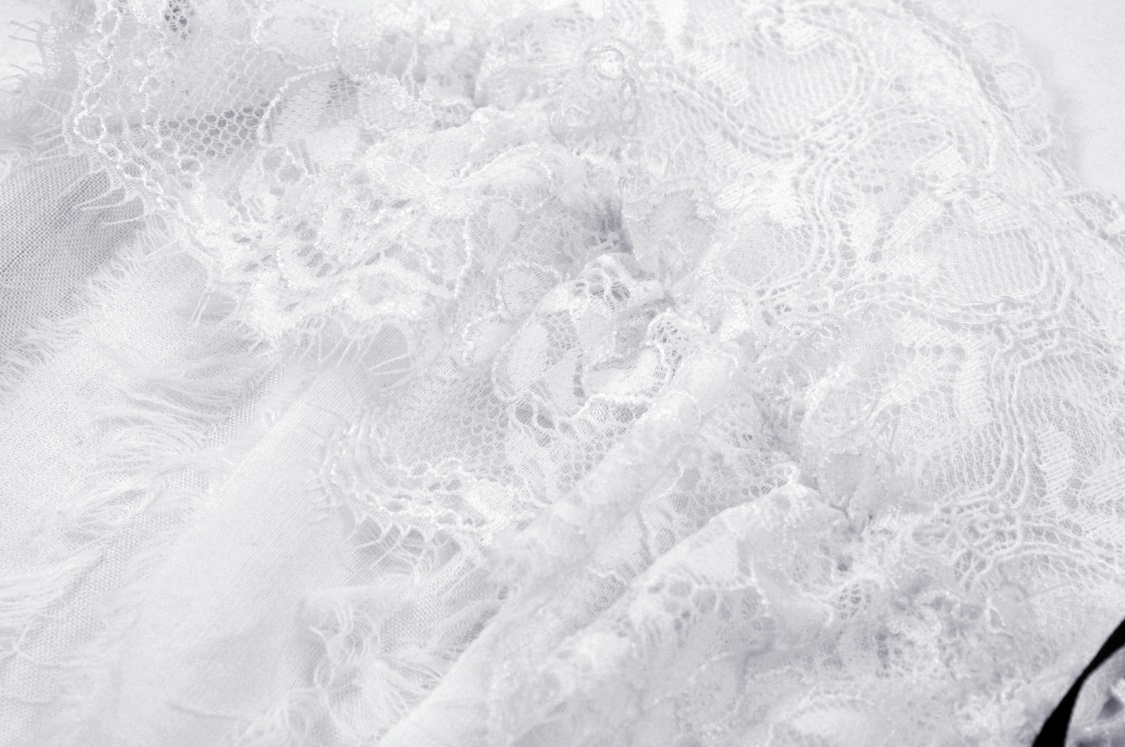 Close-up of intricate white lace fabric ideal for a punk-style sleeveless crop top.