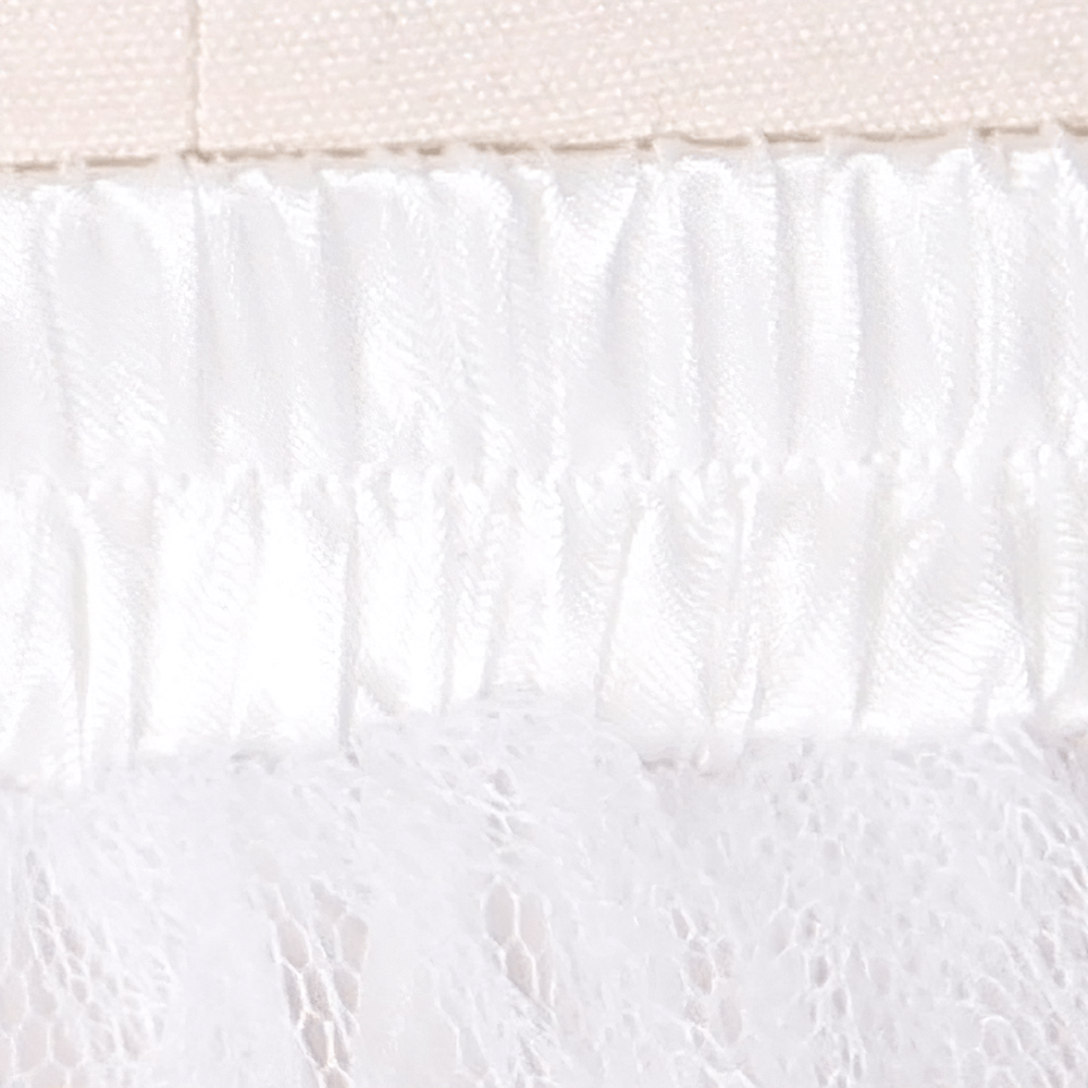 Close-up of the stretchy waistband and sheer layers of a white tulle layered skirt for gothic and punk outfits.